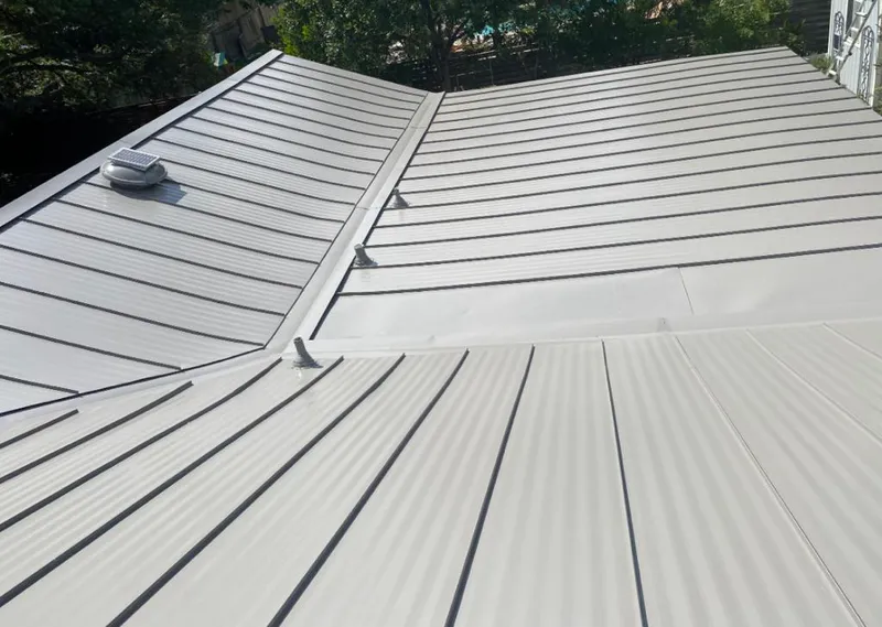 Solar attic fan installed on a metal roof for Roof Ventilation in Inwood